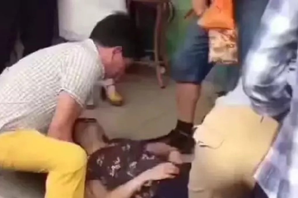 Bystanders attempt to help the woman after she passed out in the jade store. Photo: Handout