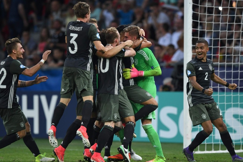 Germany players celebrate with goalkeeper Julian Pollersbeck after he saves the penalty that put his team in the final of the under-21 European Championship. Photo: AFP