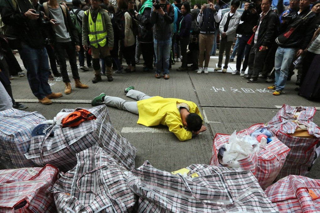 In the aftermath of Occupy, a man lies on the ground during the clearance operation in Causeway Bay.