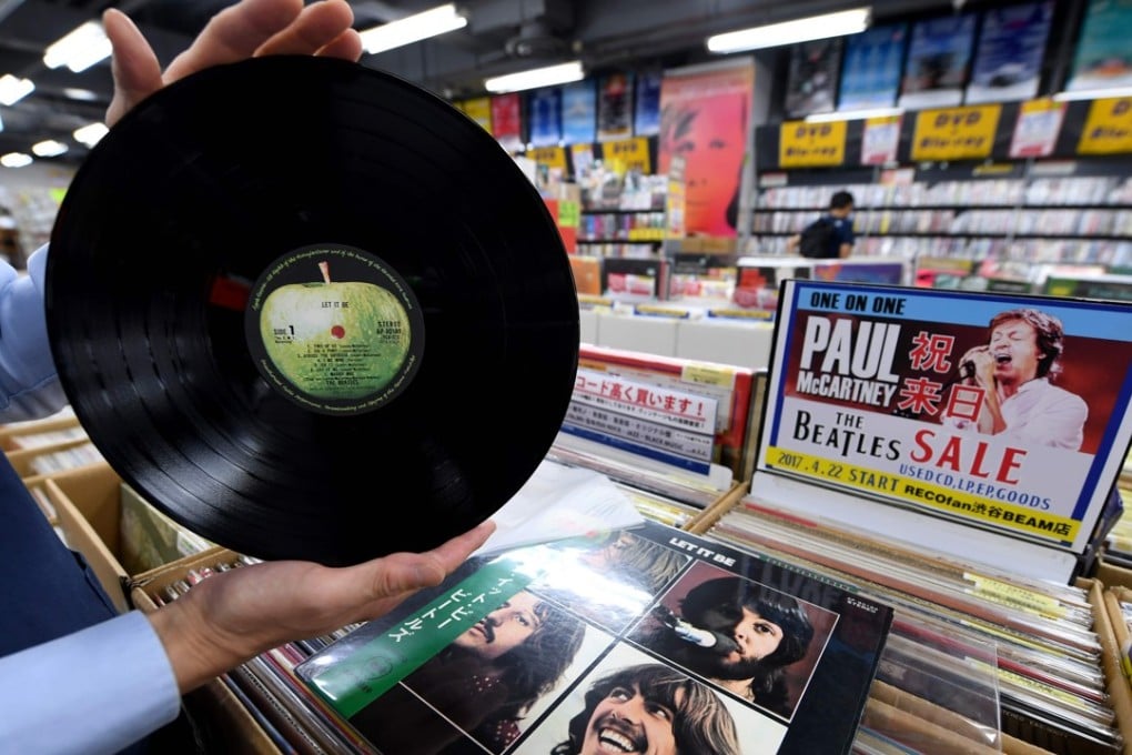 A shop manager shows off a period Japanese pressing of The Beatles' final studio album Let It Be. Photo: AFP