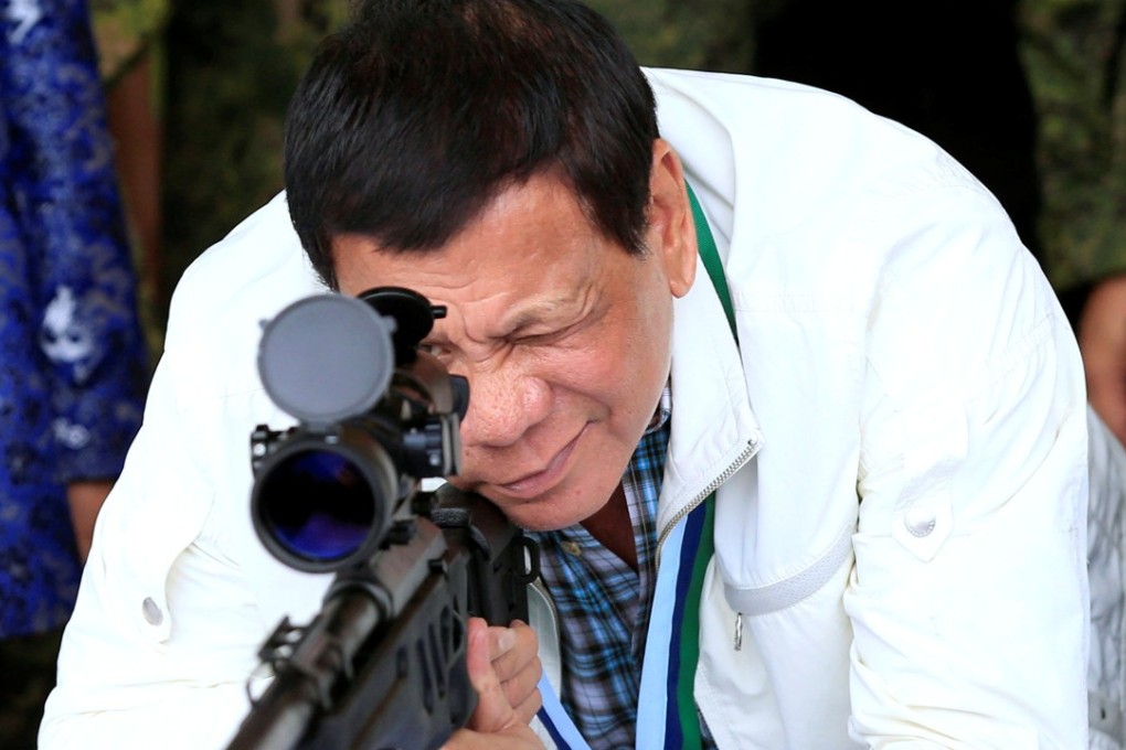 President Rodrigo Duterte at a Philippine air base, inspecting a rifle that came from China. Photo: Reuters