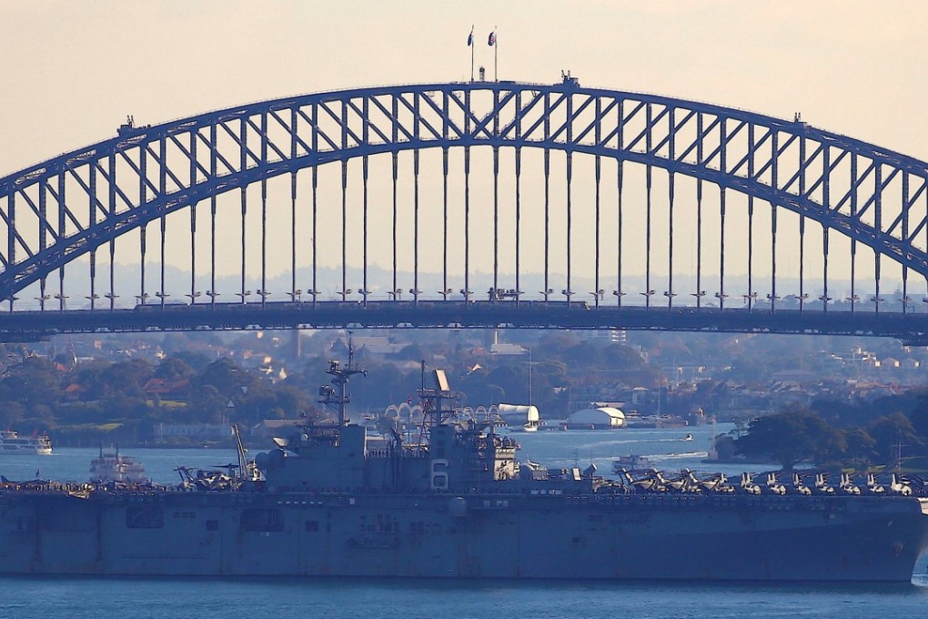 The USS Bonhomme Richard amphibious assault ship manoeuvres into port in front of the Sydney Harbour Bridge. Photo: Reuters