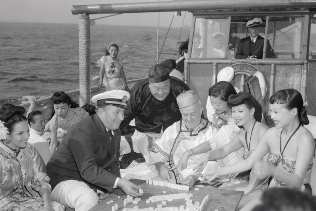 Robert Ripley (seated, in captain’s hat) and his guests enjoy a game of mahjong aboard the Mon Lei. Picture: Getty Images