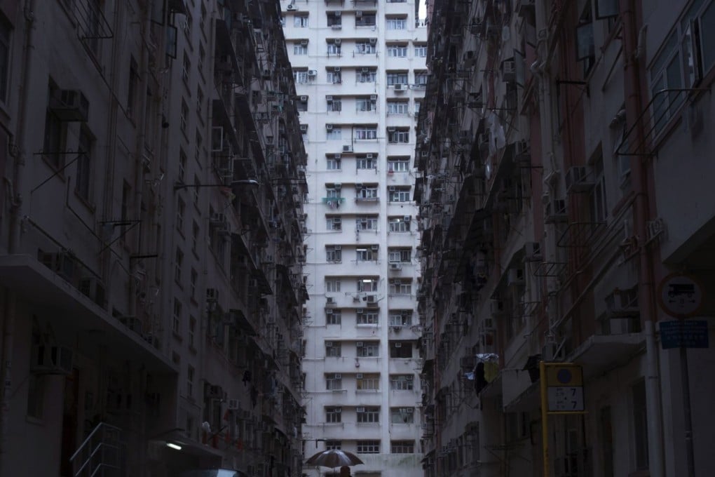 A man walks in front of a residential and commercial building, where so-called "coffin homes" are located in Hong Kong. In wealthy Hong Kong, there's a dark side to a housing boom, with hundreds of thousands of people forced to live in partitioned shoebox apartments, "coffin homes" and other "inadequate housing. Photo: AP Photo