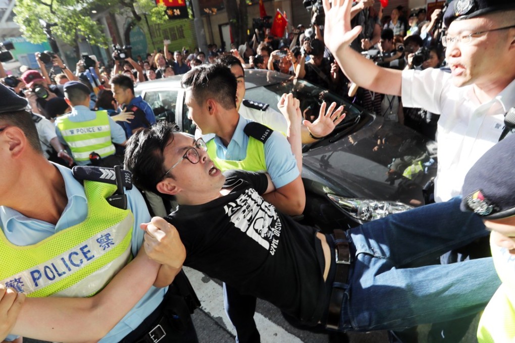 Police officers detain League of Social Demarcates chairman Avery Ng Man-yuen during a protest near the flag raising ceremony at Golden Bauhinia Square. Photo: Edward Wong