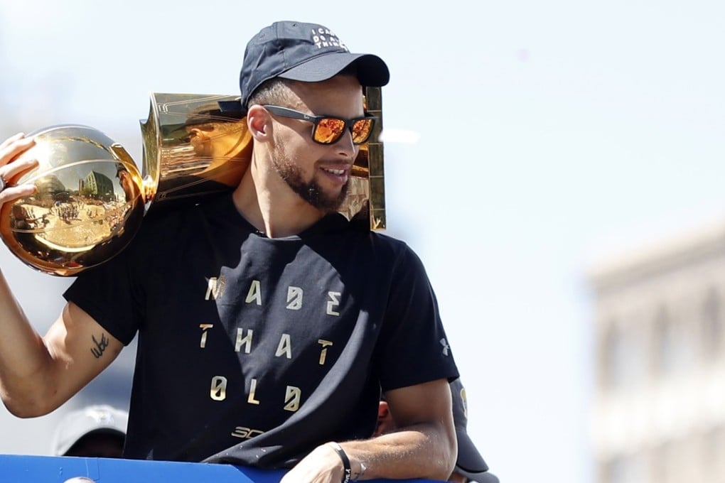 Stephen Curry holds the Larry O'Brien Trophy during the Championship Parade in Oakland. Photo: EPA