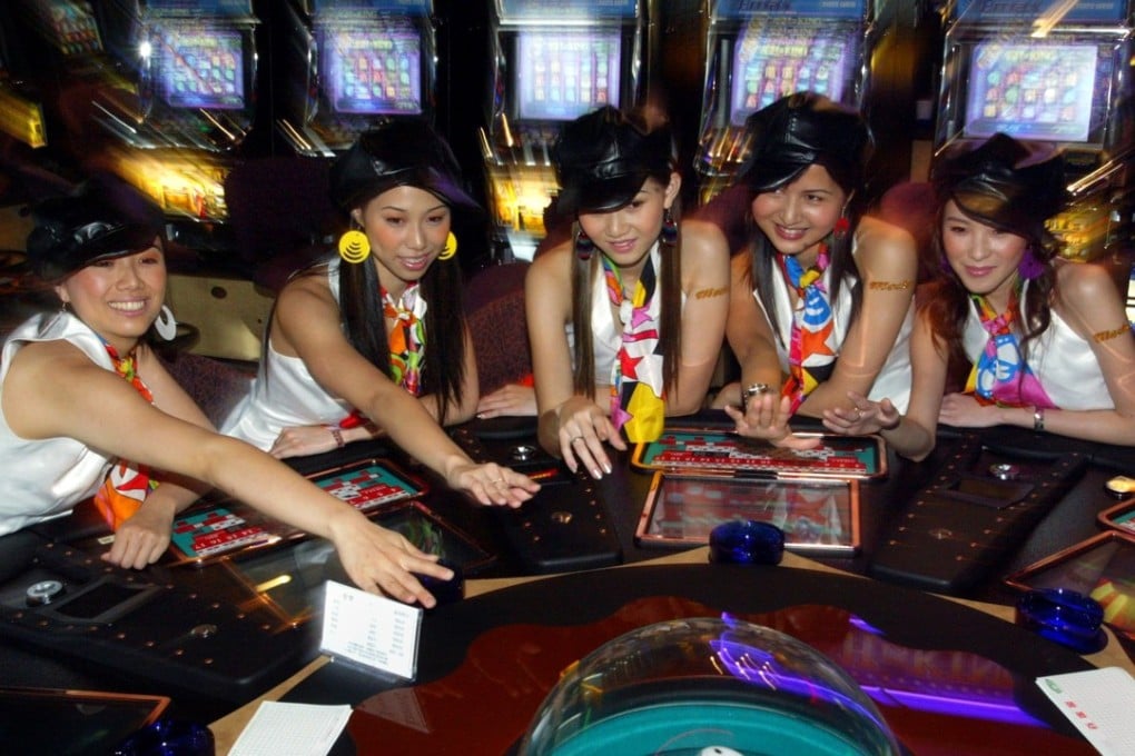 Workers pose at casino mogul Stanley Ho's new slot-machine hall in Macau which officially opened June 18, 2004. Ho invested more than HK$60 million ($7.7 million) in the 34,500-square-foot Mocha Kampek slot-machine hall which features progressive jackpots that link together groups of machines to offer bigger prizes and a frequent-gamer club with membership rewards. Photo: Reuters