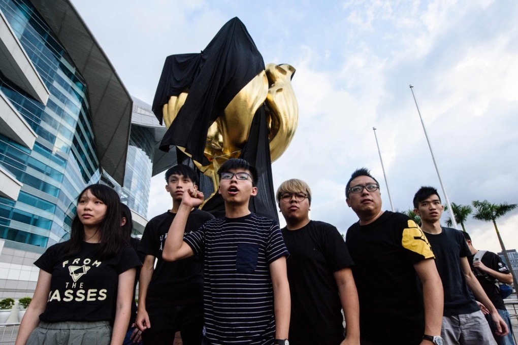 Joshua Wong and other Demosisto party members shout slogans after draping a black cloth on the Golden Bauhinia statue, on June 26. Protests such as these are likely to be interpreted by Beijing both as an objection to Hong Kong being restored to China, and as a deliberate, calculated insult to the president. Photo: AFP