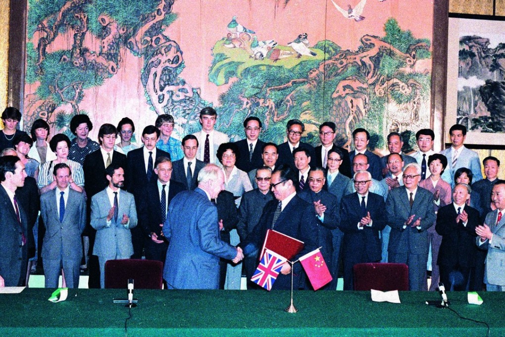 Sir Richard Evans (front left), leader of the British negotiating team for the Sino-British Joint Declaration, and his Chinese counterpart Zhou Nan exchange documents after initialling a draft agreement of the Declaration in the Great Hall of the People in Beijing. Members of the negotiating teams look on. Photo: SCMP