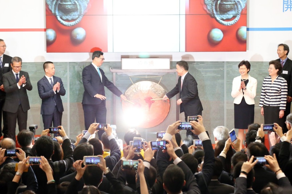 HKMA chief executive Norman Chan Tak-Lam (centre left) and deputy governor of PBOC Gongsheng strike the gong at the Bond Connect launch ceremony. Photo: Felix Wong