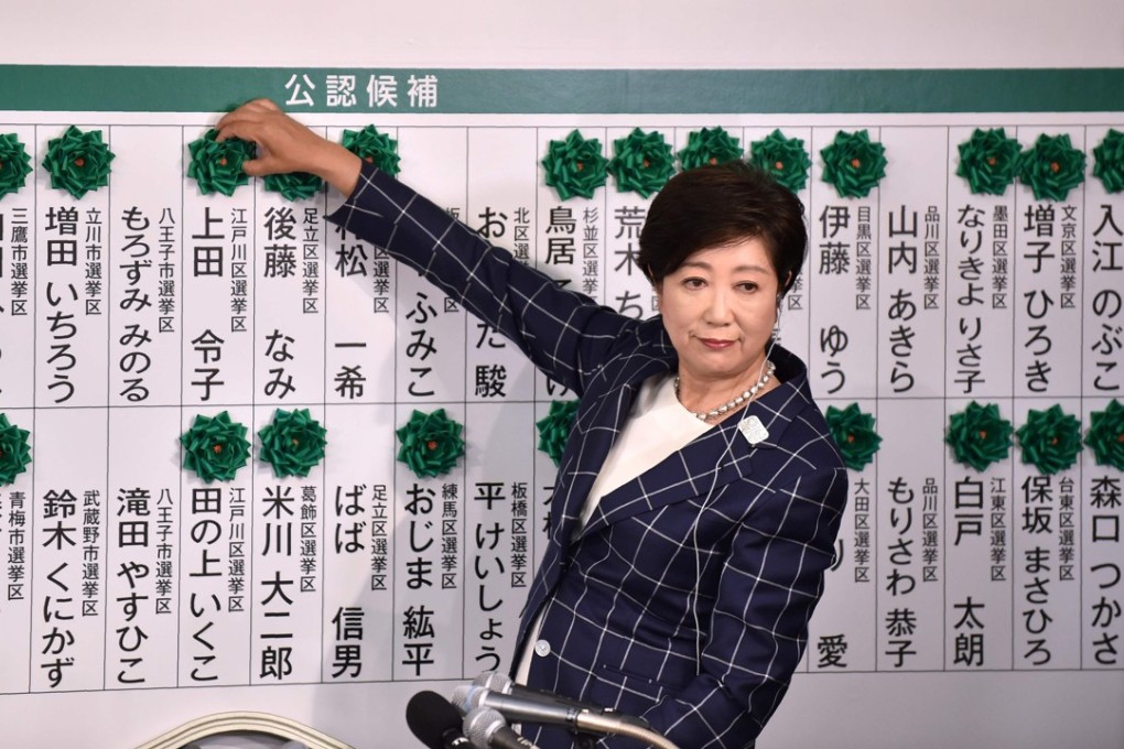Tokyo Governor Yuriko Koike marks the names of candidates who won a seat in the Tokyo metropolitan assembly election. Photo: AFP