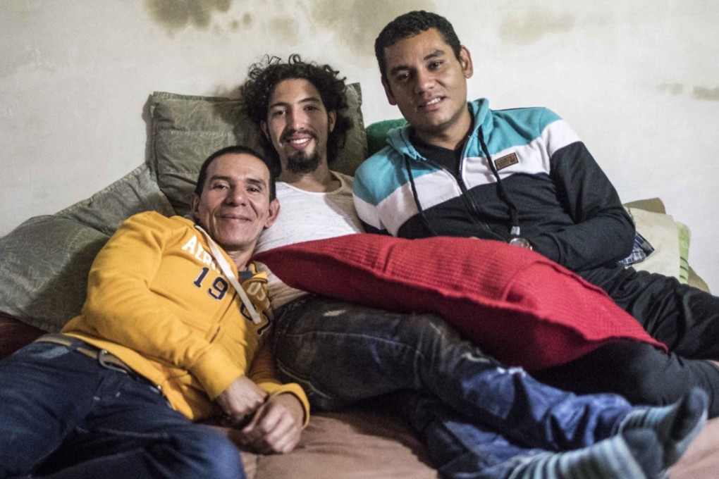Alejandro Rodriguez (left), Victor Prada (centre) and Manuel Bermudez pose for a photo at their home in Medellin, Colombia. The three men have gained legal recognition as the first polyamorous family in the country . Photo: AFP