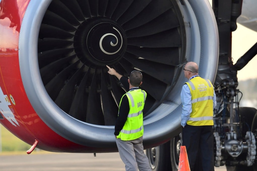 Officials inspect an engine of Malaysian budget carrier AirAsia X after it was diverted and forced to land. Photo: Reuters