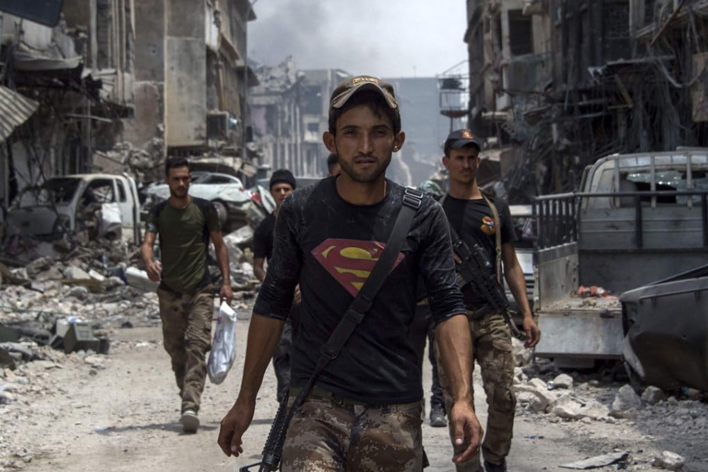 An Iraqi member of the Counter-Terrorism Services (CTS) wearing a superman T-shirt walks in the Old City of Mosul on July 3, 2017 during an ongoing offensive to retake the city from Islamic State (IS) fighters. The IS is using female suicide bombers as the battle enters its final stages. Photo: AFP