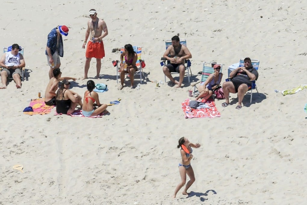 In this July 2 photo, New Jersey Governor Chris Christie (right) uses the beach with his family and friends at the governor's summer house at Island Beach State Park in New Jersey. The beach is otherwise empty because of a government shutdown that critics blame on Christie. Photo: AP