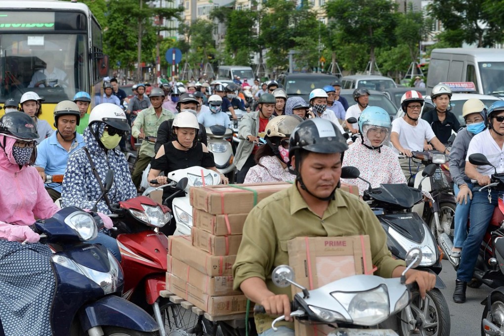 Motorcyclists cross an intersection in downtown Hanoi. Photo: AFP