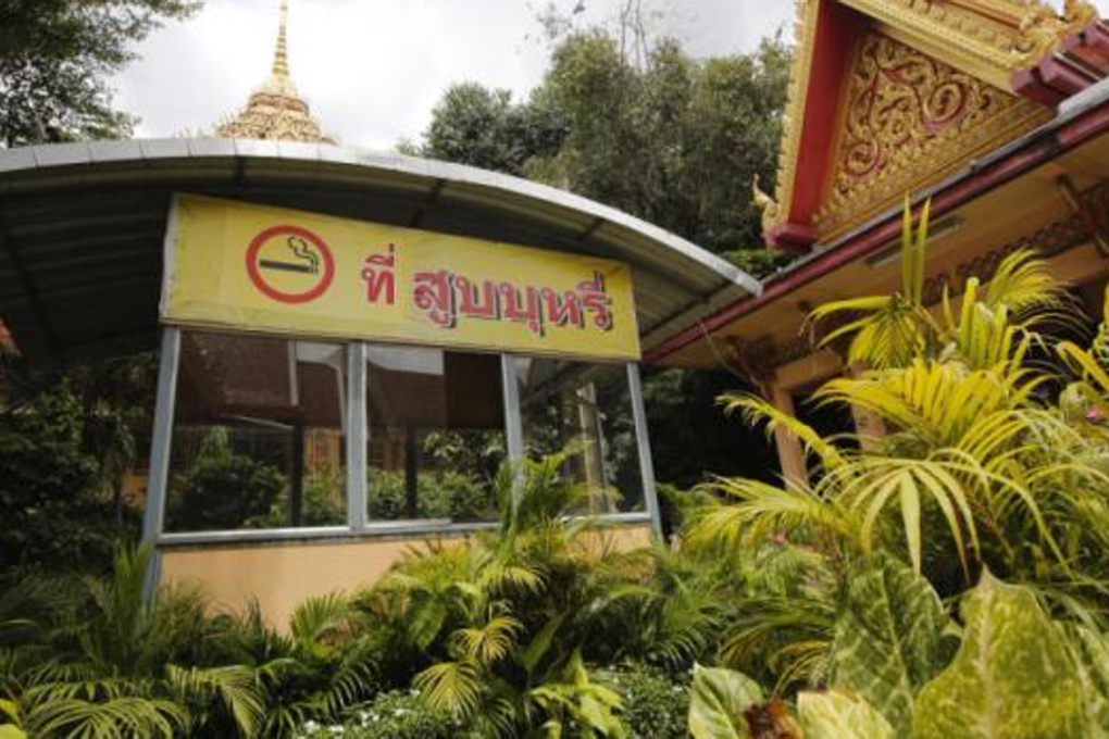A sign is put up at the entrance to Wat Samian Naree in Bangkok to designate a space for smokers as the latest amendment to the tobacco control law goes into effect. Photo: Wichan Charoenkiatpakul