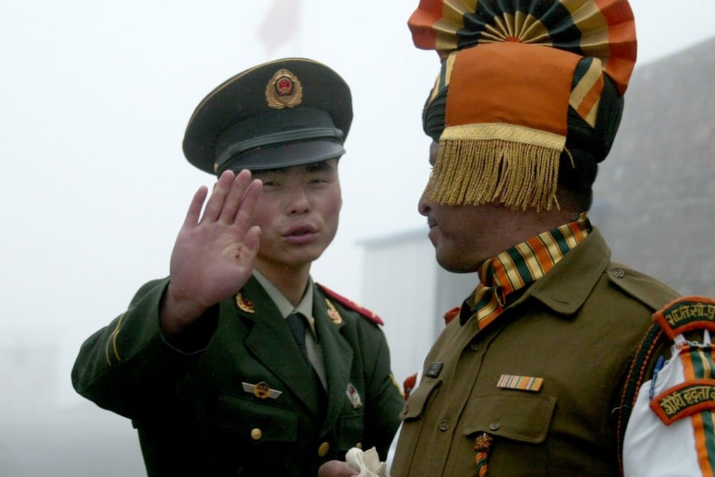 A Chinese soldier gestures beside an Indian soldier on the border between the two countries in this file photo.The two sides have recently been engaged in a military stand-off sparked by a road construction project. Photo: AFP