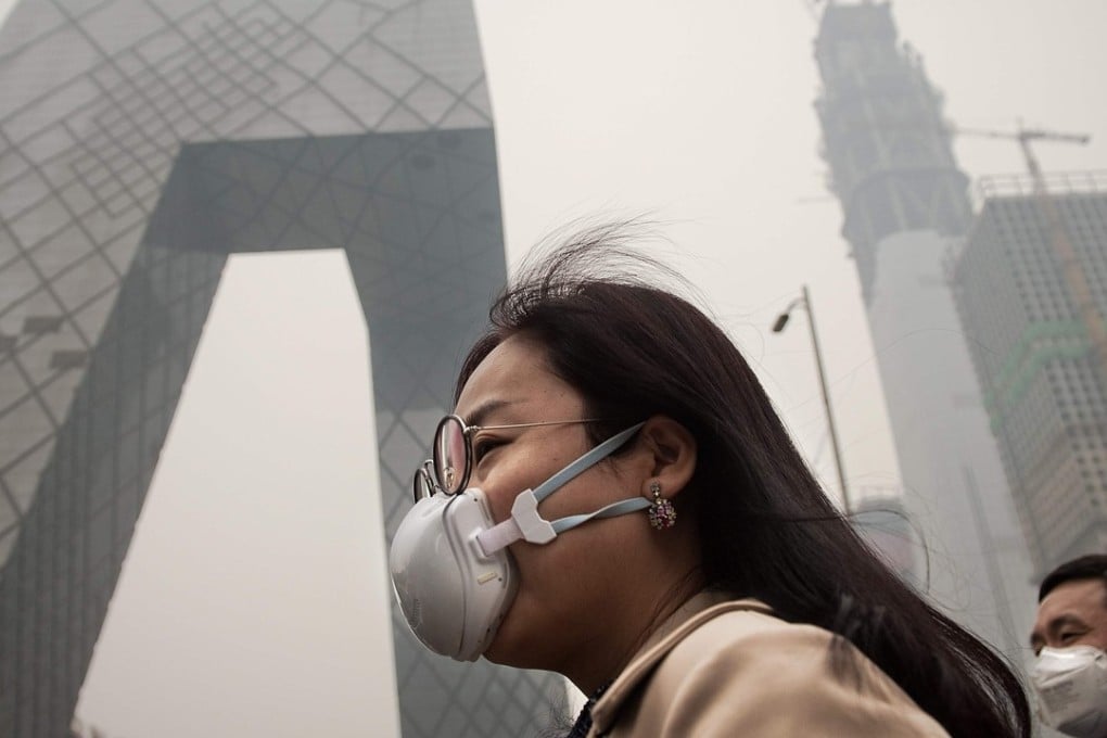 A woman wearing a protective mask walks on a street in Beijing, to try and protect herself from the city’s bad air pollution. Photo: AFP