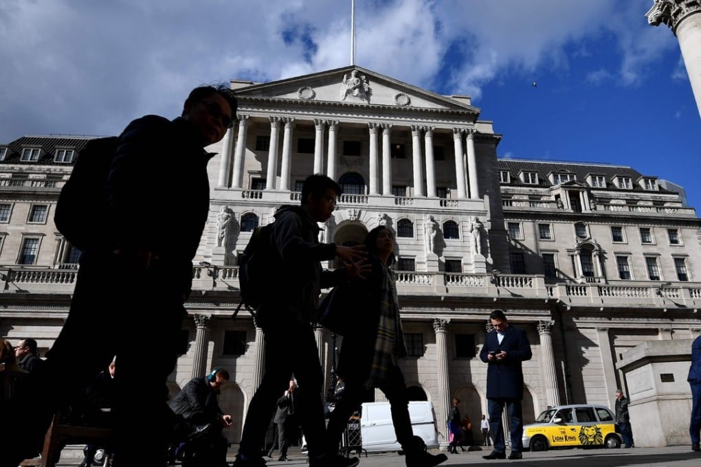 People walking past The Bank of England in the City of London. For the first time in five decades, staff at the bank voted for a strike action at the end of July. Photo: AFP