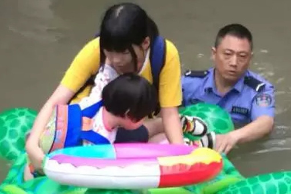 A police officer helps a woman and child steer the inflatable turtle to safety. Photo: Handout