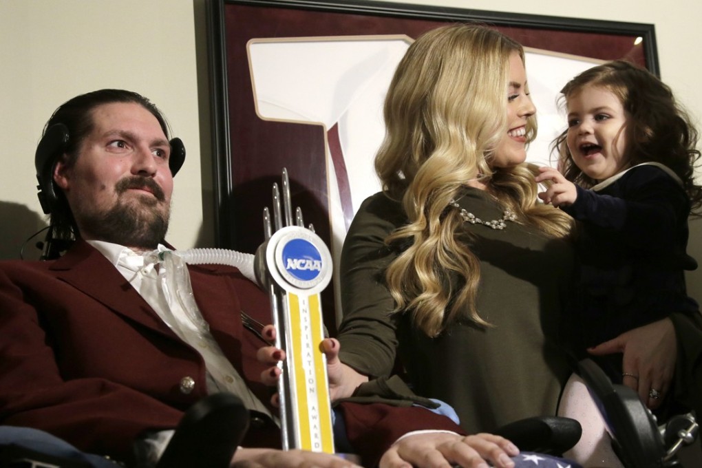 In this December 13, 2016, file photo, Pete Frates, left, appears with his wife Julie, center, and two-year-old daughter Lucy, right, after he was presented with the 2017 NCAA Inspiration Award, at their home in Beverly, Massachusetts. Photo: AP