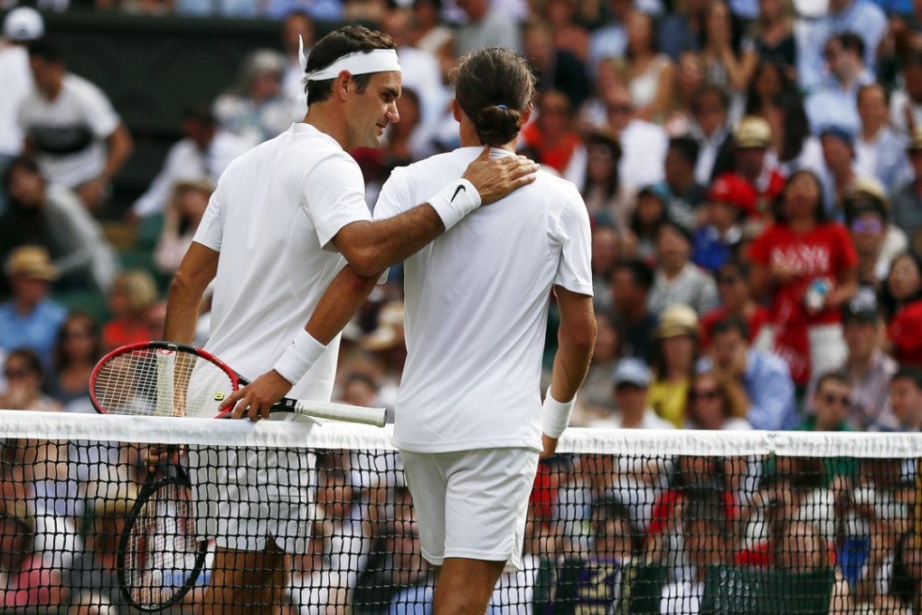 Roger Federer at the net with Alexandr Dolgopolov after the Ukrainian retired injured in their first round match. Photo: EPA