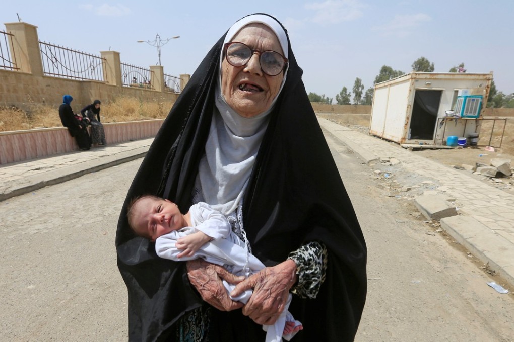 A displaced Iraqi woman carries a baby after fleeing from Islamic State in Mosul. Photo: Reuters