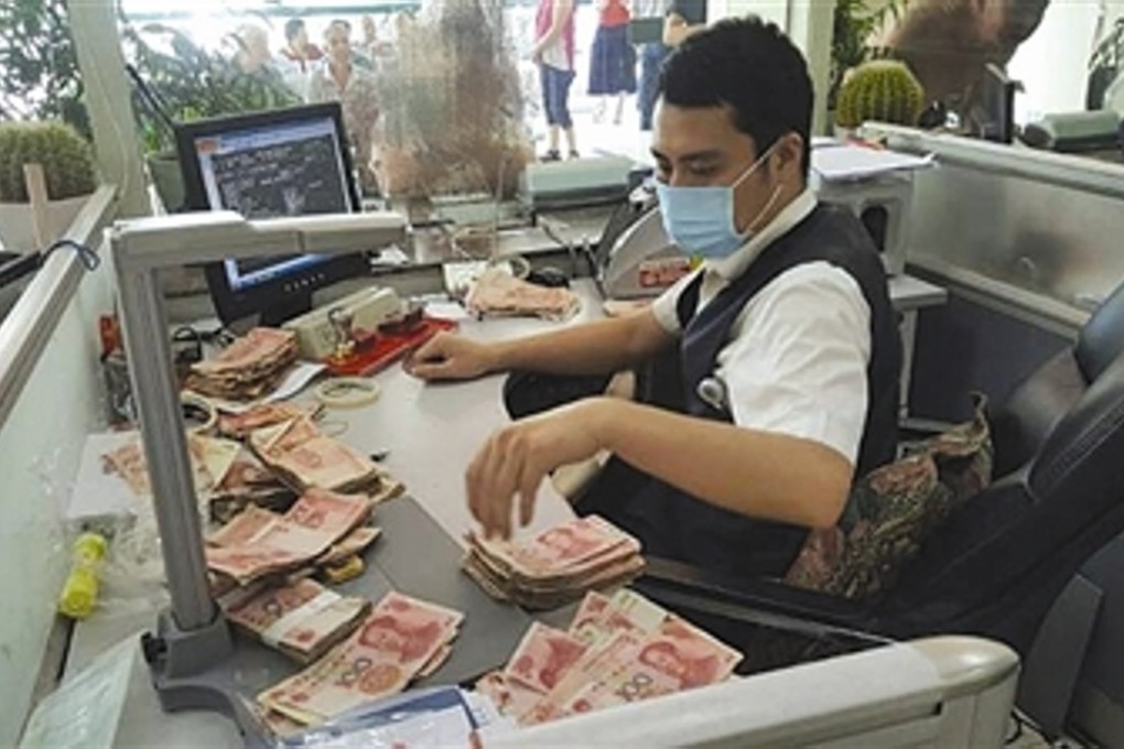 A bank teller, wearing a mask, counting the rancid smelling notes. Photo: Handout