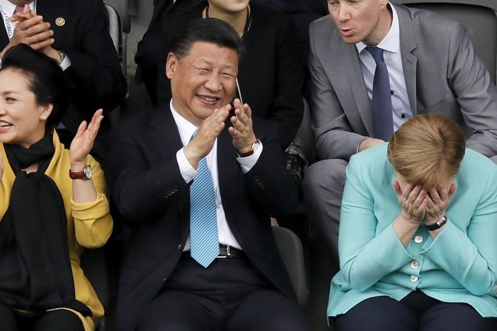 Xi Jinping cracks an unusually large grin as he watches the Germany-China under-12 match with his wife Peng Liyuan and German chancellor Angela Merkel. Photo: EPA