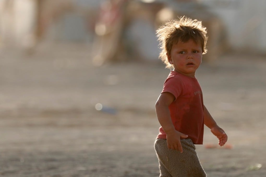 A boy displaced from fighting in the Islamic State stronghold of Raqqa walks in confusion looking for relatives near the village of Karama, east of Raqqa, Syria. Photo: Reuters