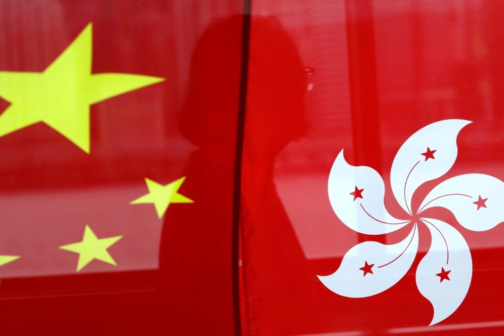 A woman is reflected in a window behind Chinese and Hong Kong flags after celebrations commemorating the 20th anniversary of Hong Kong's handover. That Hong Kong is a part of China is in the constitution, and that constitutional framework must become reality that is accepted by all. Photo: Reuters