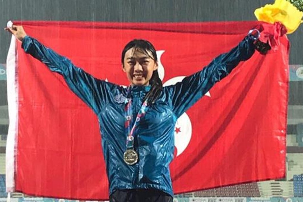Cecilia Yeung Man-wai celebrates her silver medal as the rain pours down at the Asian Championships in India. Photo: Facebook / Hong Kong Amateur Athletic Association