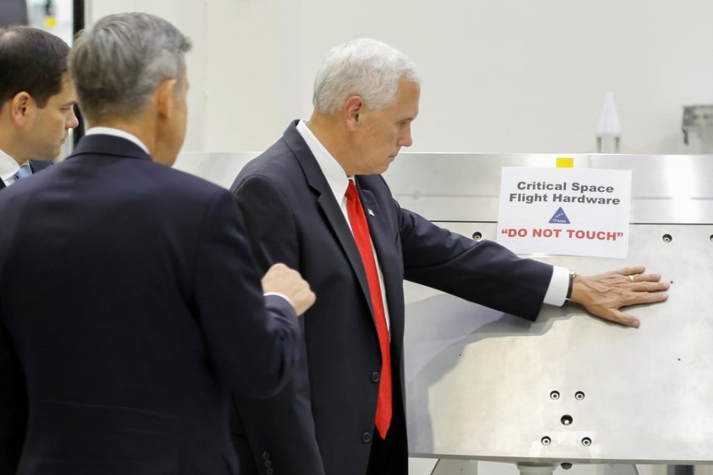 US Vice-President Mike Pence touches a piece of hardware with a warning label “Do Not Touch”. Photo: Reuters