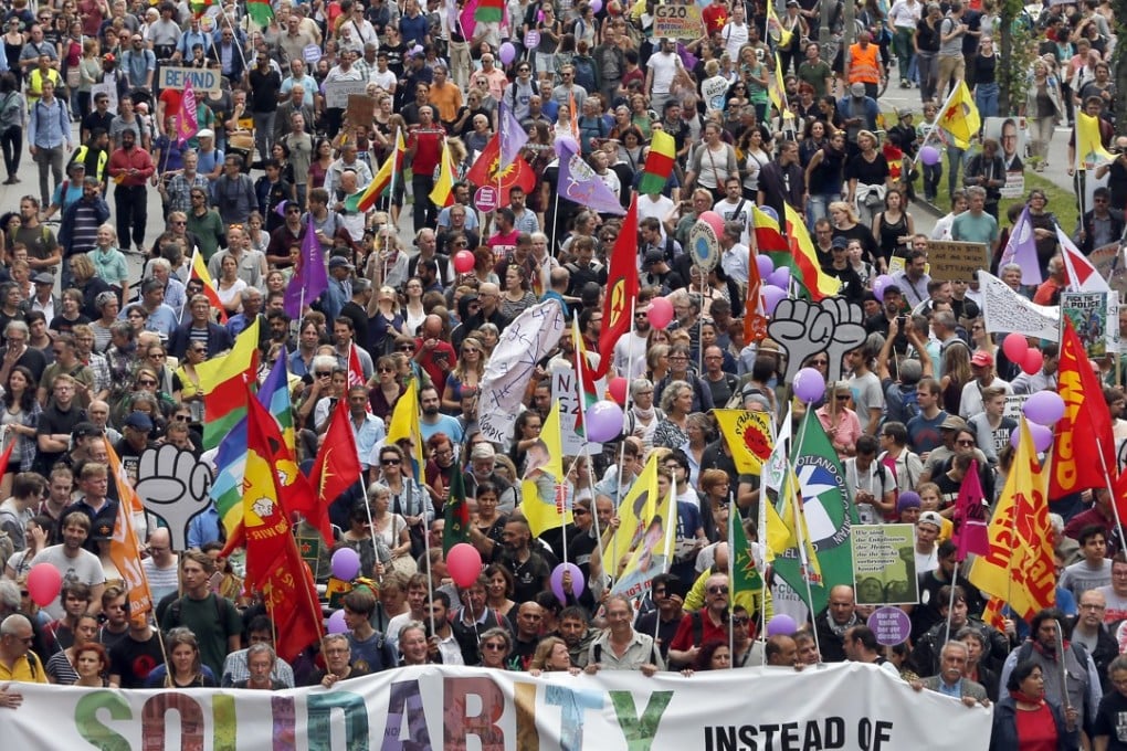 People wave flags during a protest against the G20 summit in Hamburg, Germany. Photo: AP