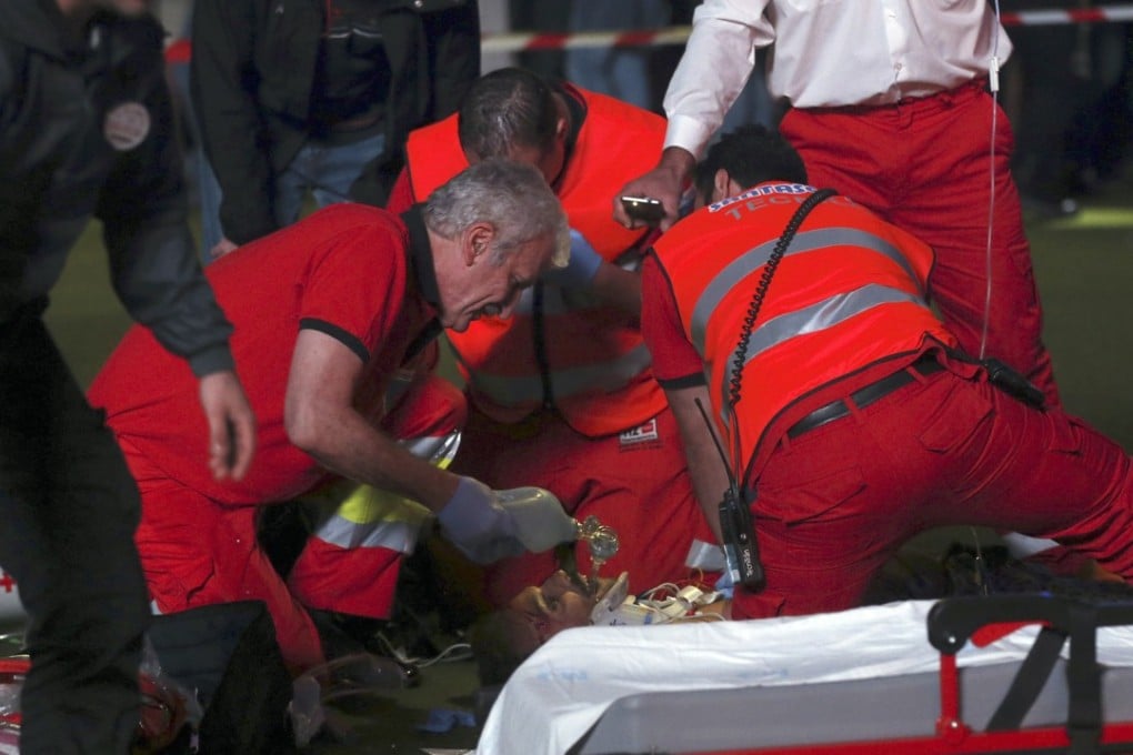 Emergency services attempt to help the fallen acrobat. Photo: EPA