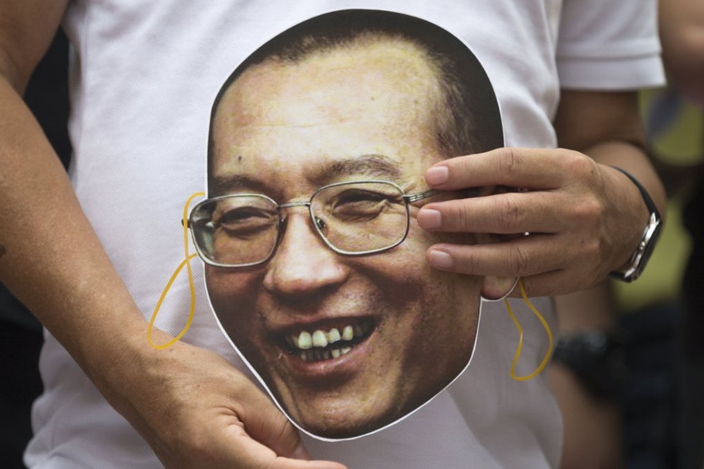 A protester holds a mask with the face of Chinese dissident and Nobel laureate Liu Xiaobo during a protest outside the central government’s liaison office in Hong Kong on June 27. Photo: EPA