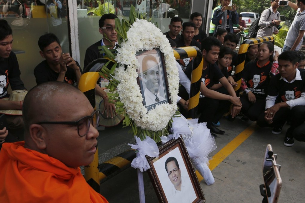 A Cambodian monk takes a selfie with portraits of independent political analyst Kem Ley during a ceremony in Phnom Penh on Monday, when supporters marked Kem Ley's one-year death anniversary. The Cambodian political commentator and activist was shot dead at a Star Mart Caltex gas station in Phnom Penh on 10 July 2016. Photo: EPA