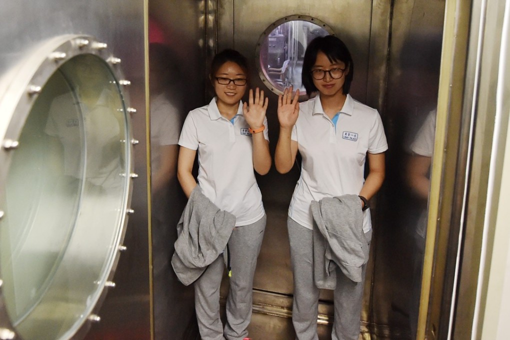 Two volunteers prepare to enter the simulated space station in Beijing. Two women and two men are scheduled to stay in the facility for 200 days. Photo: Xinhua