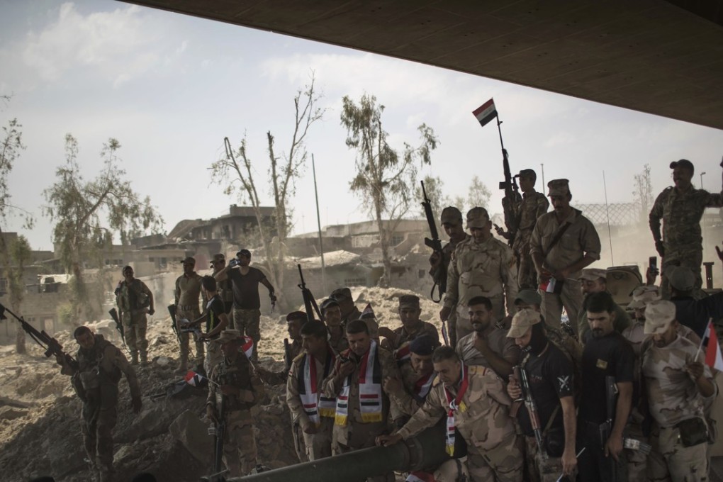 Iraqi Army soldiers gather to celebrate their gains as their fight against Islamic State militants continues in the Old City of Mosul, Iraq. Photo: AP