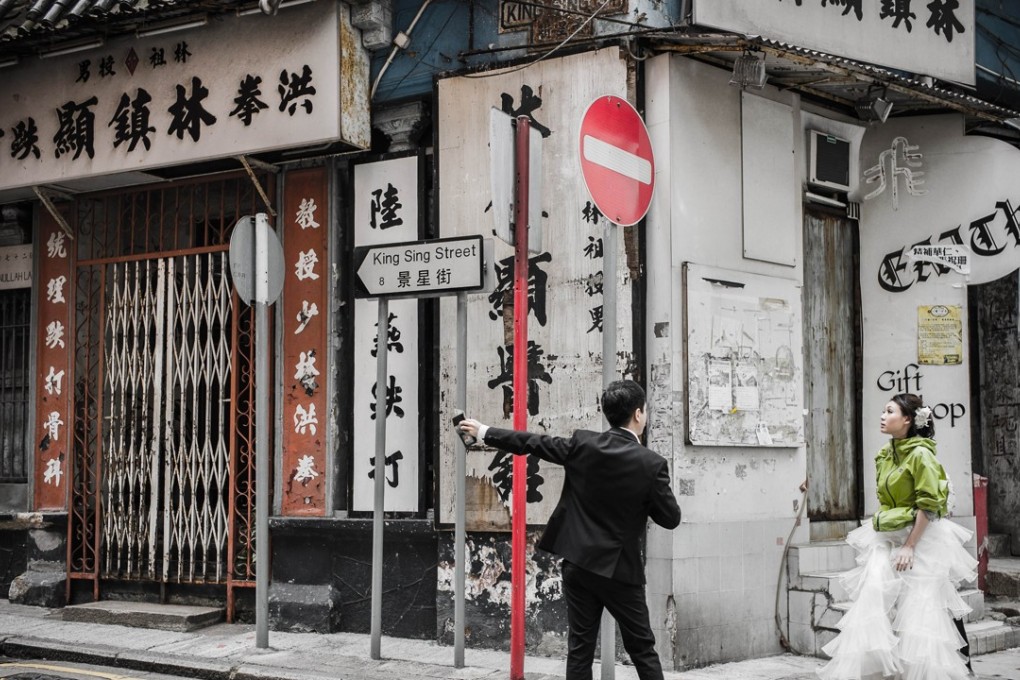 A just-married couple look for a location to have their picture taken in Hong Kong. Most weddings in the former British colony blend Western and Chinese traditions. Photo: AFP