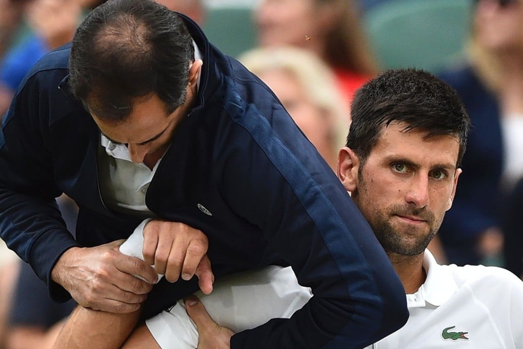 Novak Djokovic gets some medical attention on court in a break between games. Photo: AFP