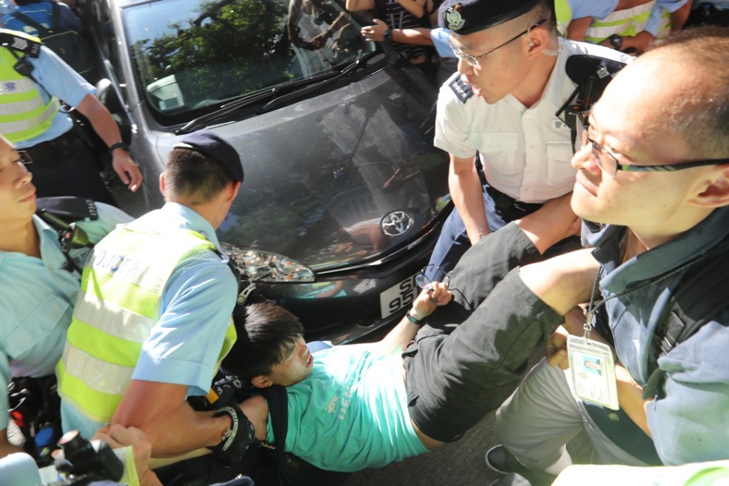 Police officers carrying Joshua Wong away during a protest near the flag raising ceremony at the Golden Bauhinia Square. Photo; Edward Wong