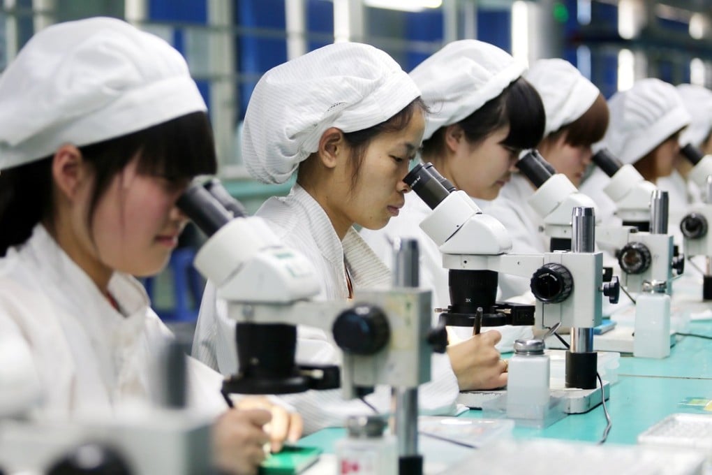 Workers assembling parts for mobile phones at a factory in Anhui province. Photo: EPA
