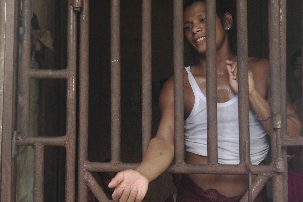 Kyaw Naing, a slave from Myanmar, talks to a security guard through the bars of a cell at the compound of a fishing company in Benjina, Indonesia, in 2014.Photo: AP