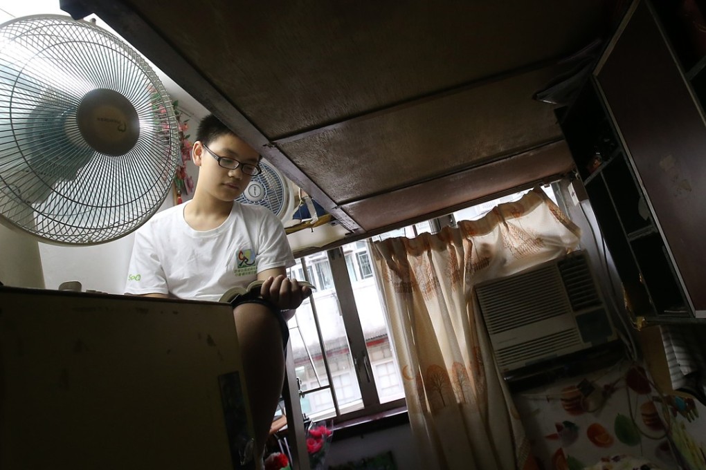 Wong Chak-ming, 12, in his 30 sq ft “coffin home” in Sham Shui Po, one of five carved out of a 500 sq ft flat. Photo: David Wong