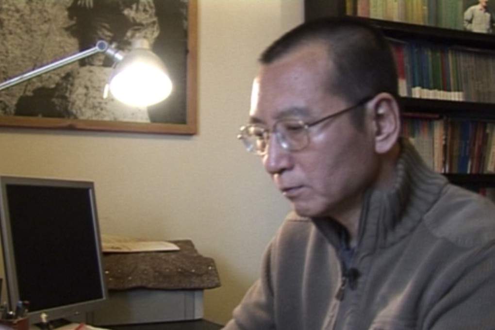 Liu Xiaobo looks at documents in his home in Beijing in this file photo. Photo: Associated Press