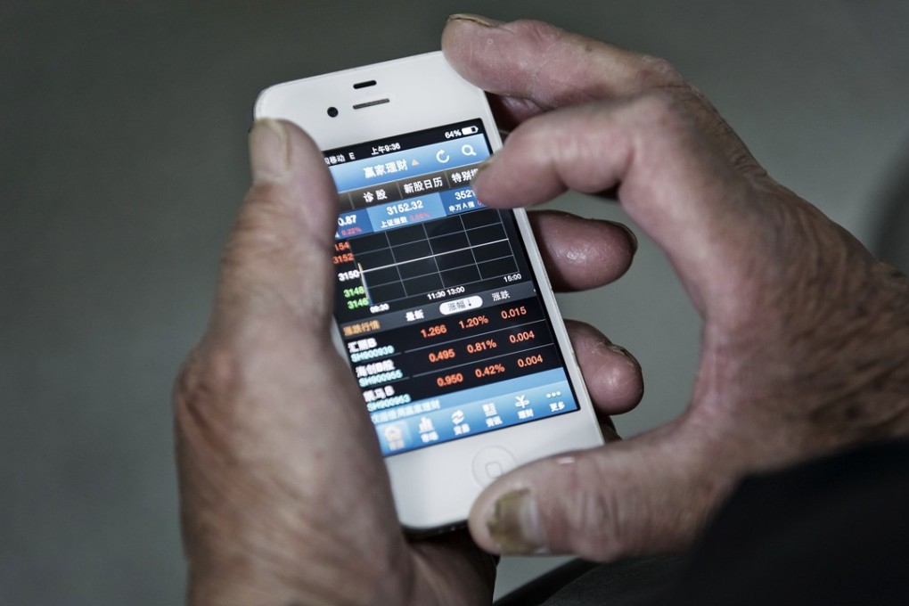 An investor uses a smartphone displaying share prices at a securities brokerage in Shanghai last month. The Shanghai Composite Index rose 0.6 per cent to 3,218.16 on Thursday. Photo: Bloomberg