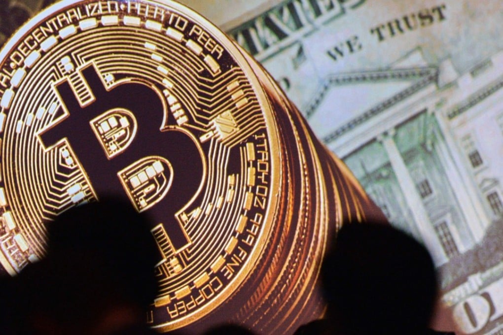 An image of Bitcoin and US currencies is displayed on a screen as delegates listen to a panel of speakers during the Interpol World Congress in Singapore on July 4, 2017. Photo: AFP