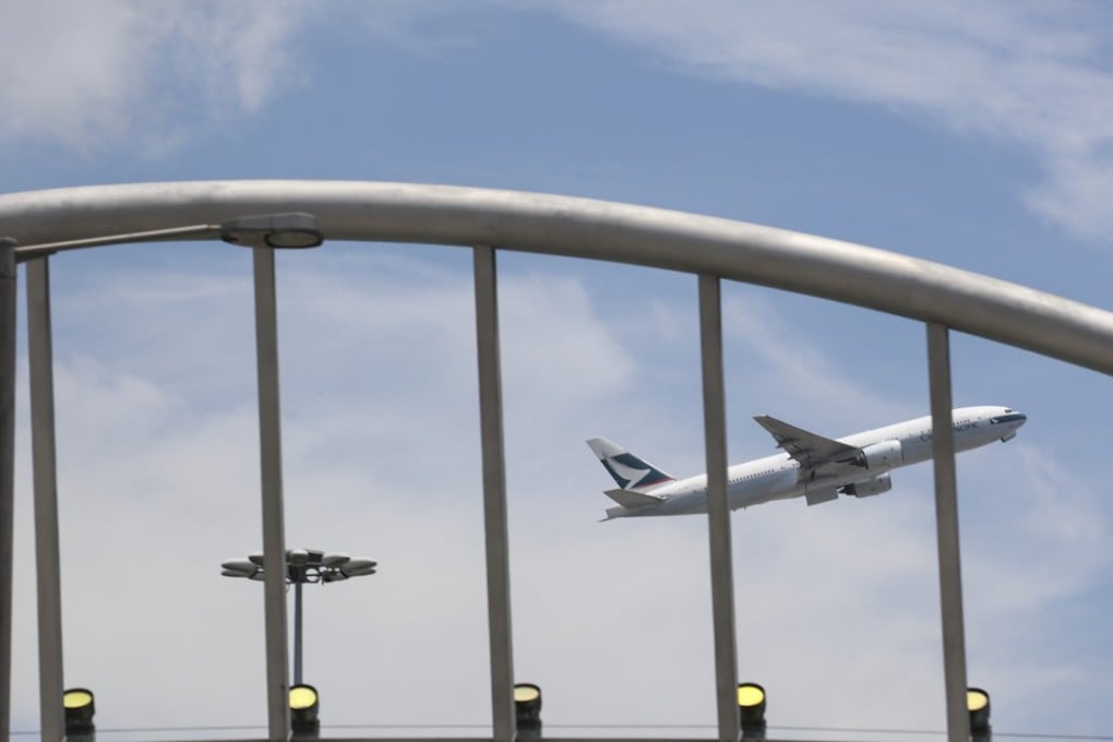 A Cathay Pacific plane flies over Lantau. Intense competition sparked by open skies deals may see airlines forced to cut costs and trigger large-scale layoffs. Photo: Felix Wong